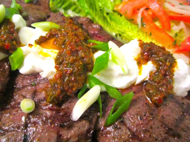 arrange salad and steaks on serving platter, top steaks with spicy chimichurri and greek yoghurt
