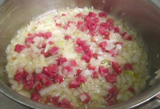 simmer smoked pork shank in salted water until tender, about 2,5 hours. Meanwhile, saute onions and chorizo in duck fat
