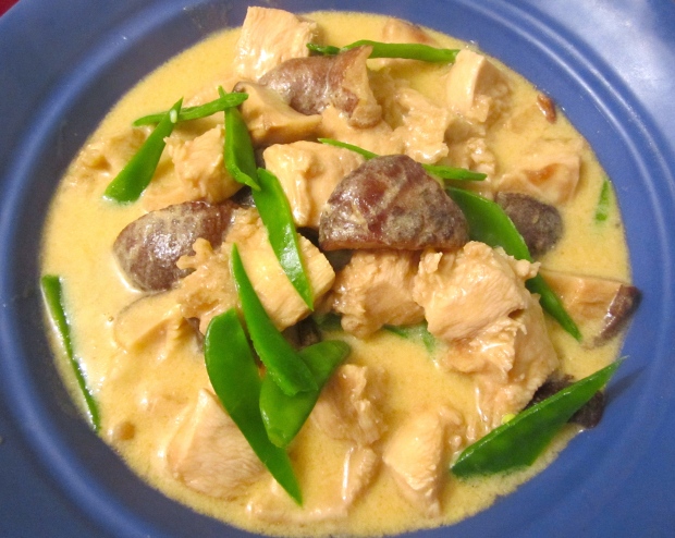 ladle soup with chicken and shiitake on top of pasta and snow peas