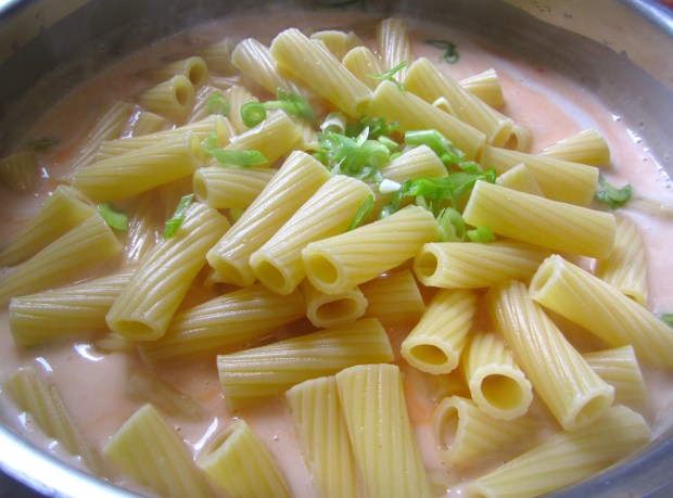 add freshly cooked, al dente pasta and sliced scallions
