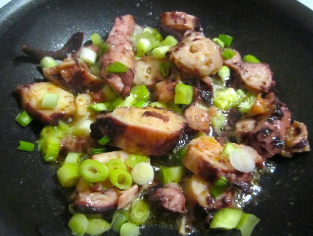 season drained octopus pieces with kosher with garlic paste, salt and cayenne pepper, saute in olive oil until heated, add finely sliced scallion
