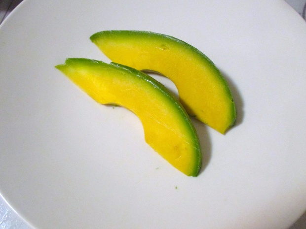 add two generous slices of avocado to hot serving plate
