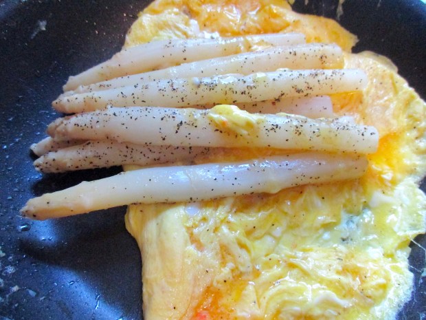 make an omelette with four whole eggs, seasoned with kosher salt and cayenne pepper, fold asparagus into omelette